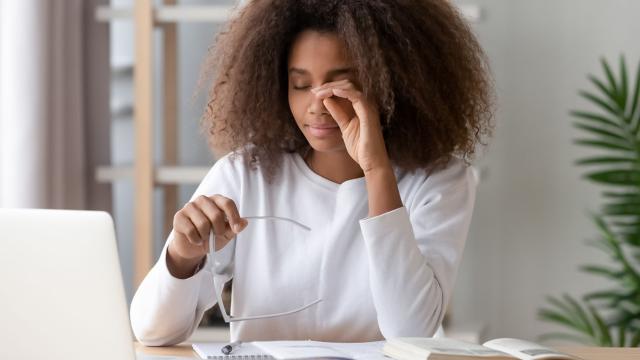 Woman taking off glasses to rub her eyes.