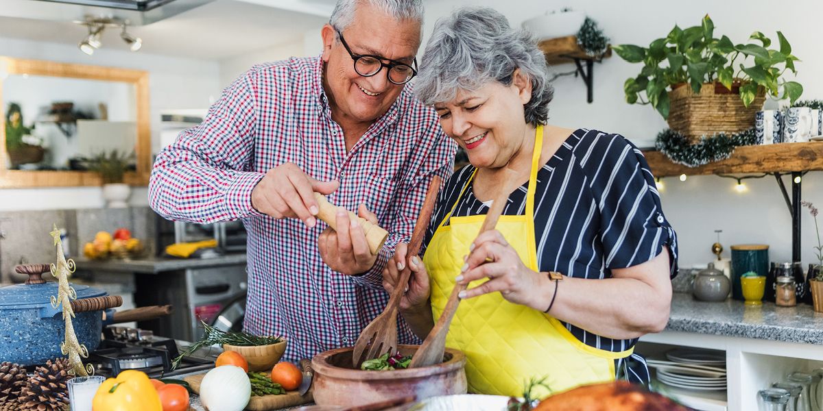Senior man and woman cookin together