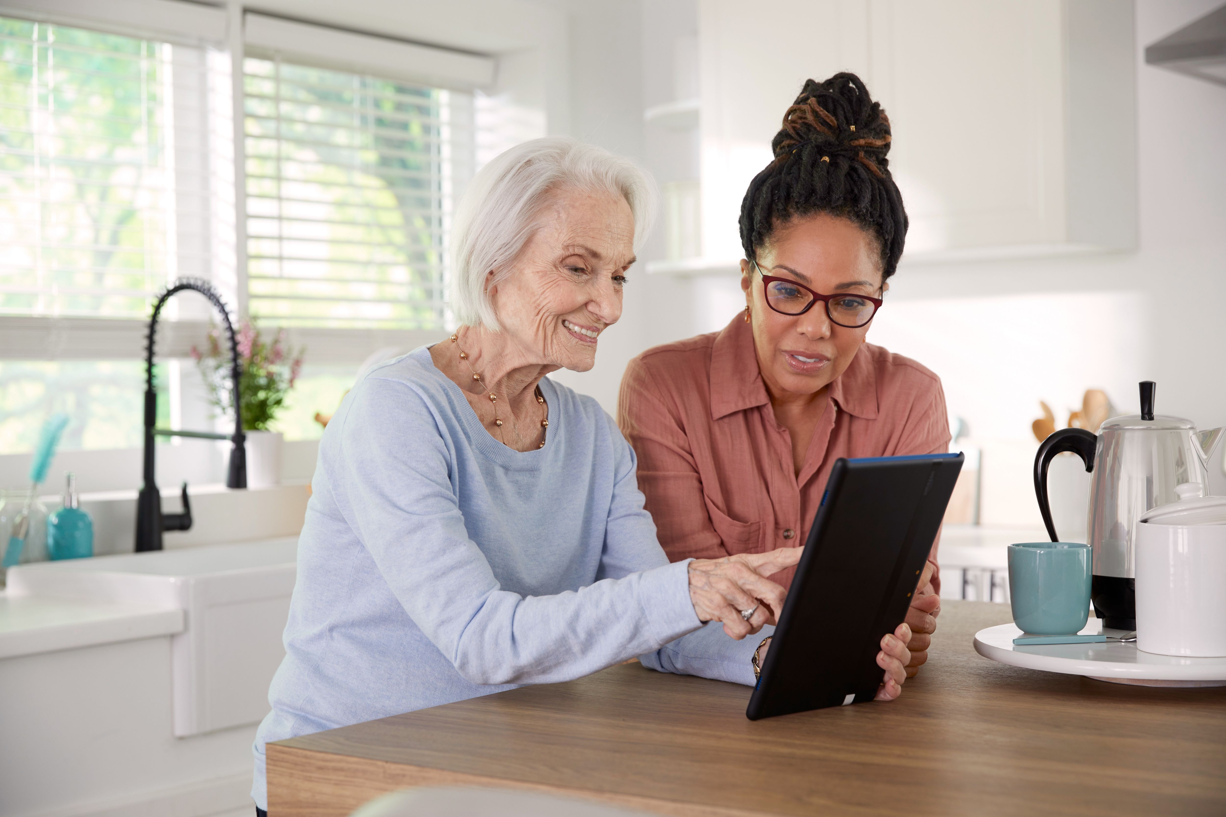 Caregiver and member are in kitchen looking at tablet