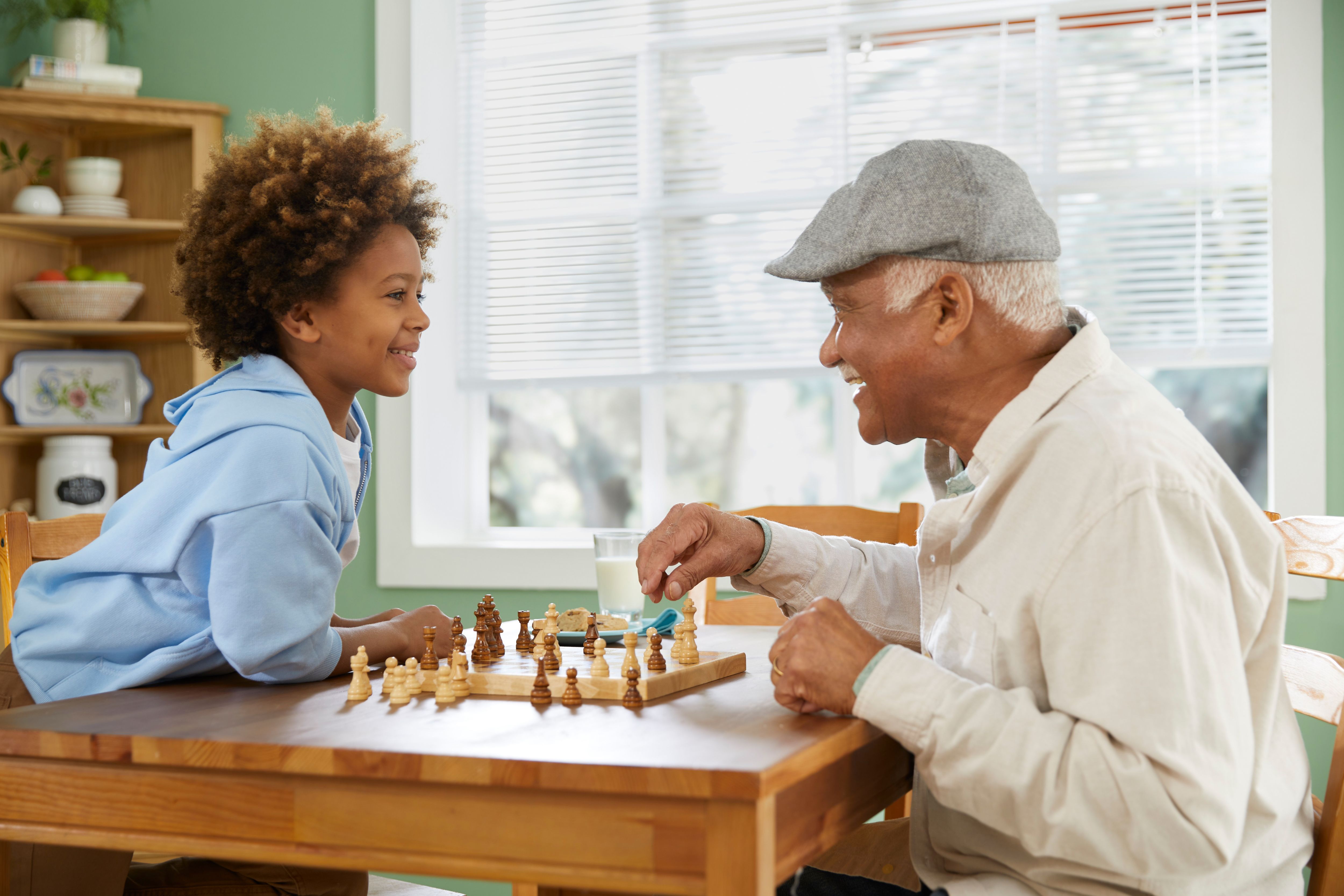 Grandfather and grandson play chess together