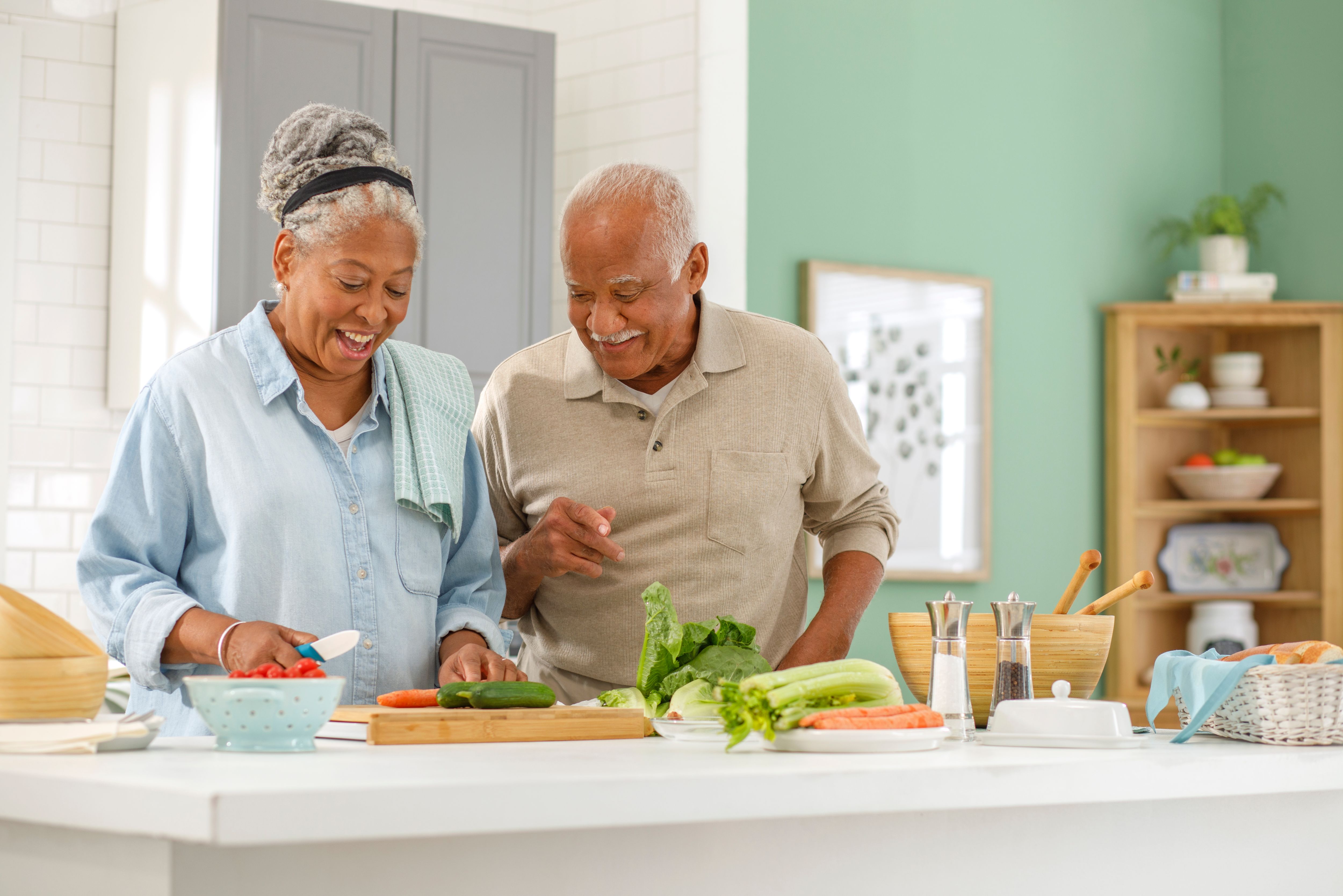 Senior couple are preparing food together in the kitchen