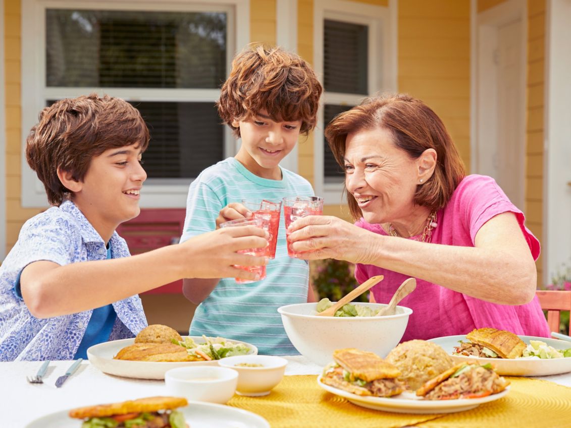 Grandmother drinking lemonade with her grandsons.