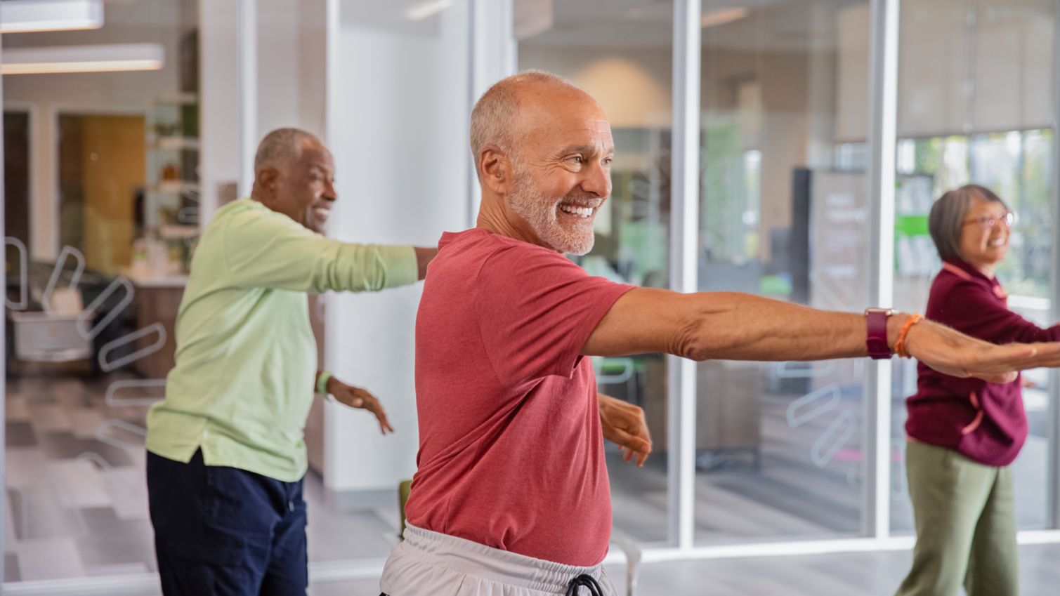 A man and a woman ride exercise bikes at a fitness facility.