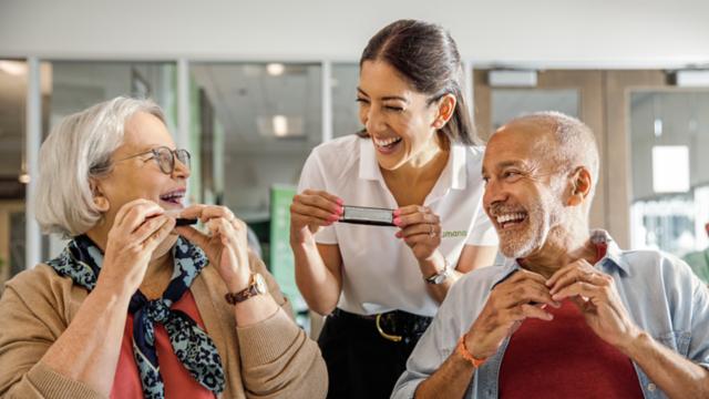 A couple learns to play the harmonica in a class. 