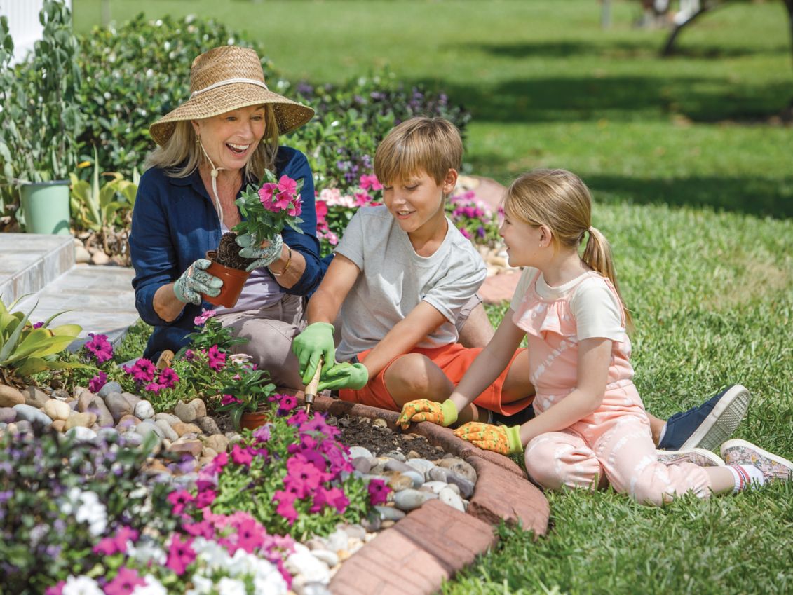 Grandmother gardening with her grandchildren.