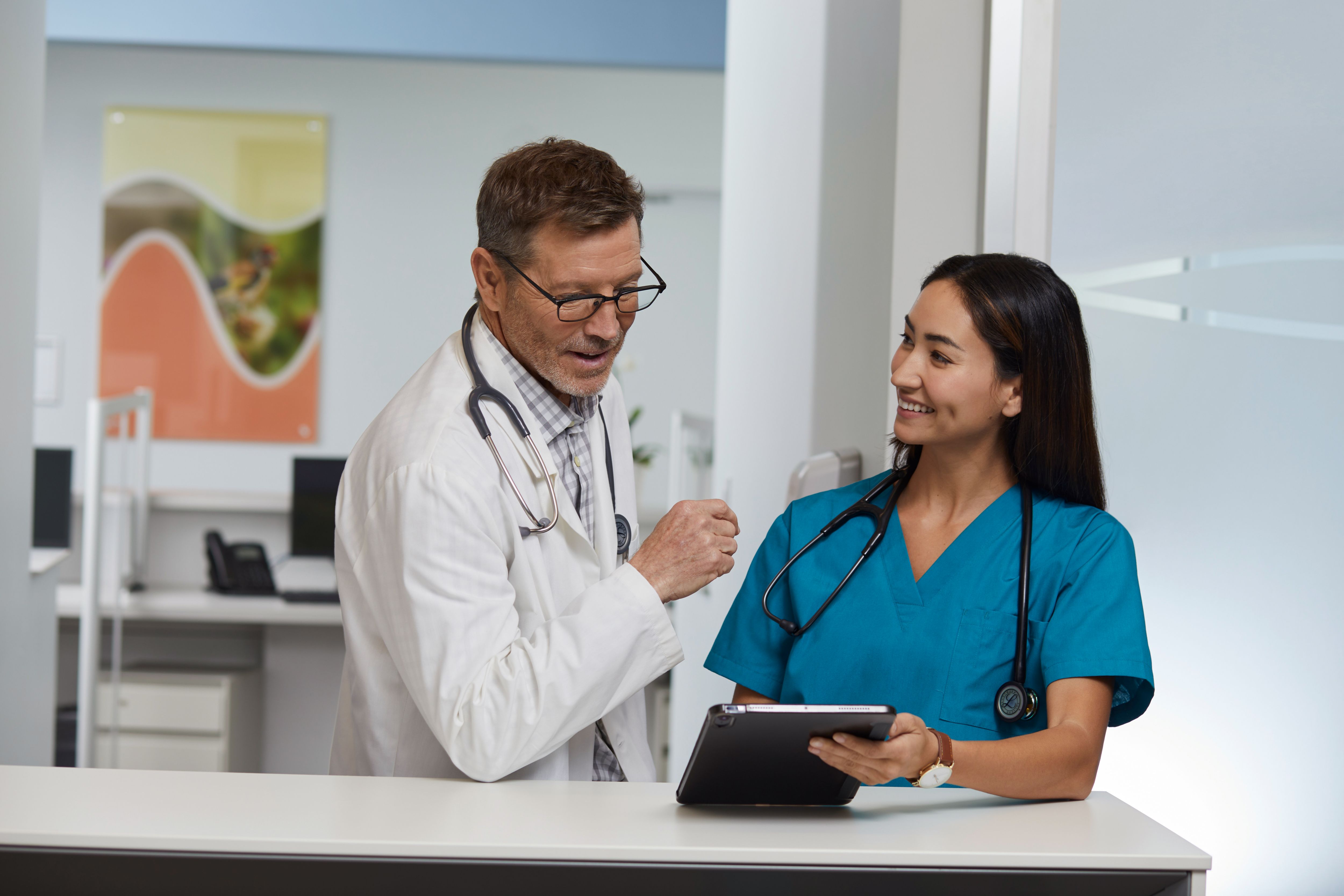 A doctor and a nurse review a patient's chart. 