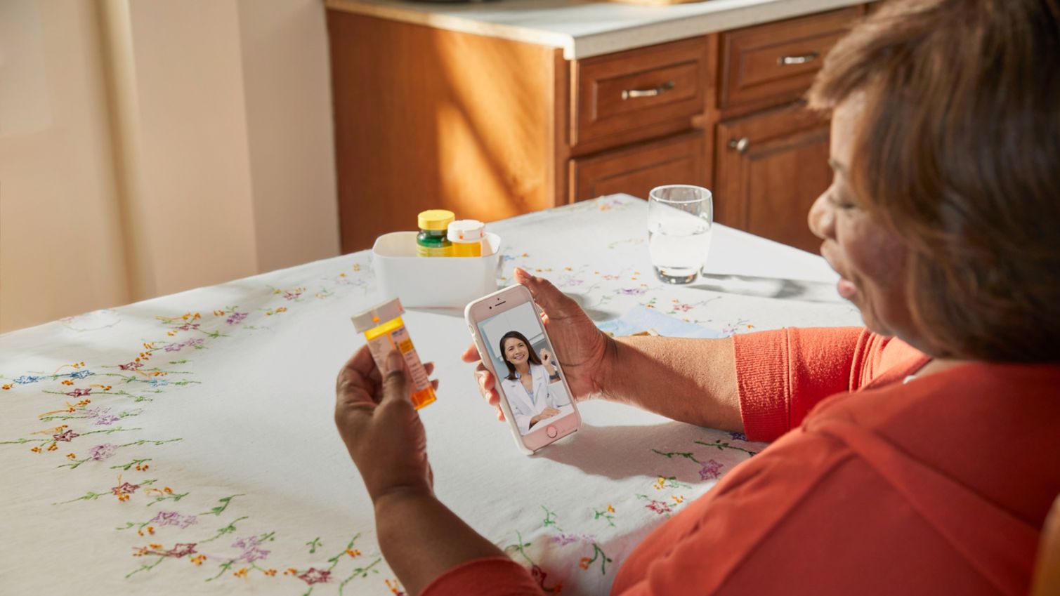 A woman uses her smartphone for a telehealth visit. 