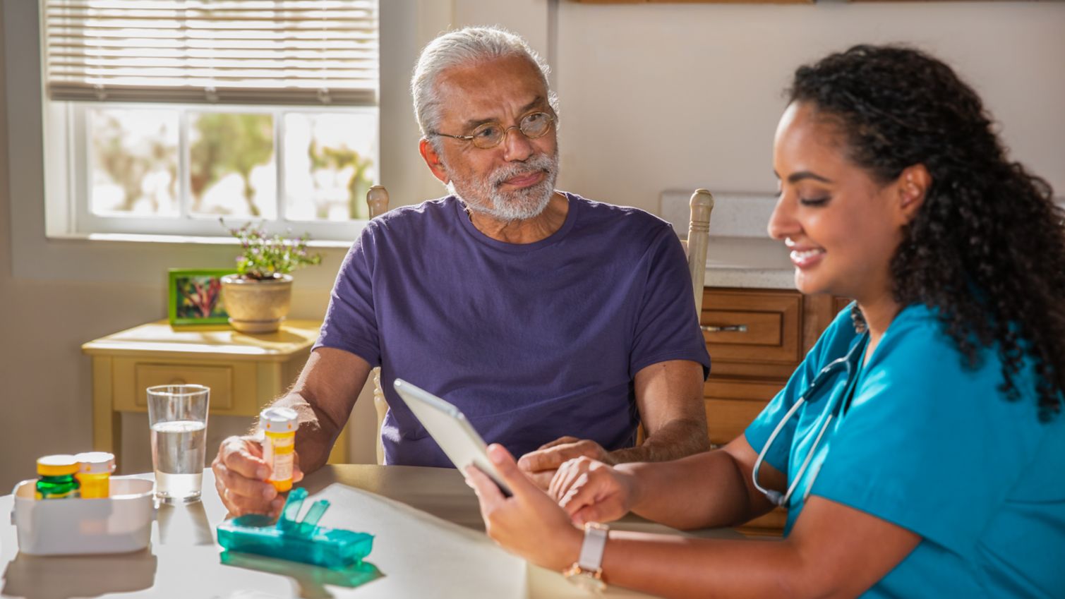 A man meets with a care manager at his kitchen table.