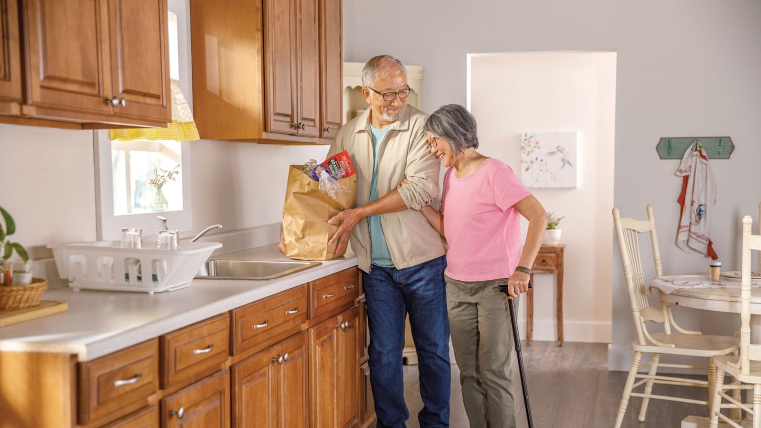 A couple puts groceries away together.