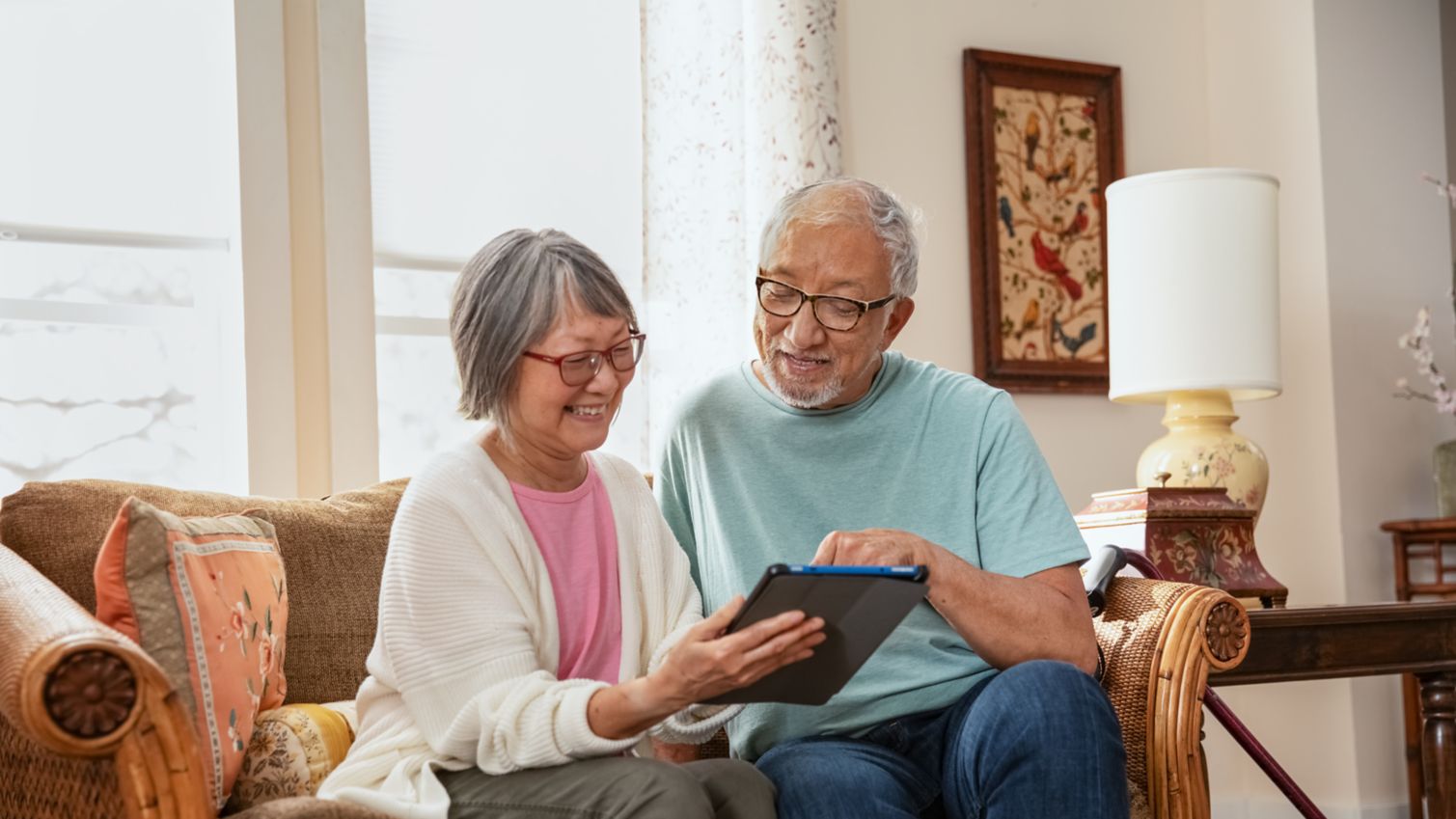 A couple uses a tablet in their living room.