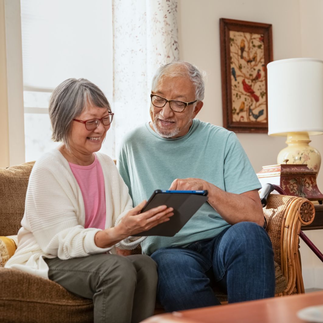 Couple on couch reviewing web page