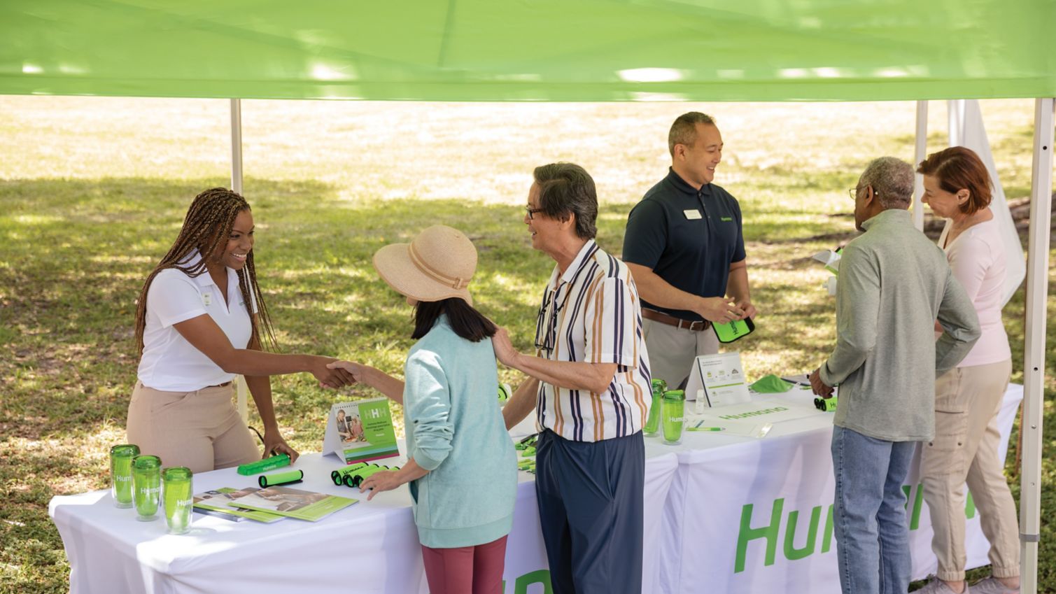 Two couples meet with Humana representatives at an outdoor event.