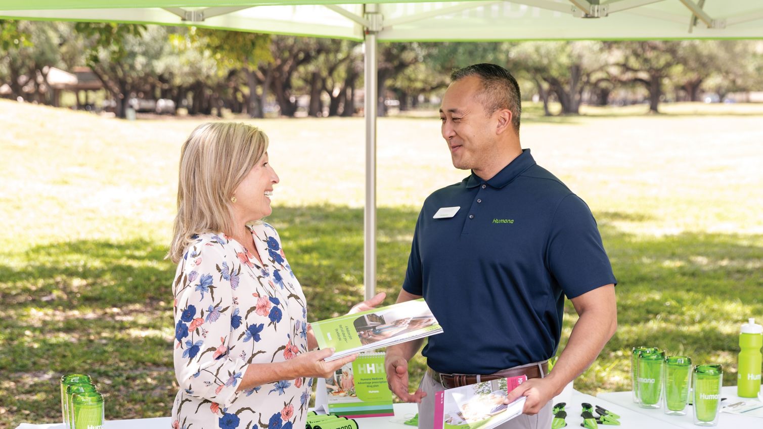 A woman chats with a Humana agent at an outdoor event. 