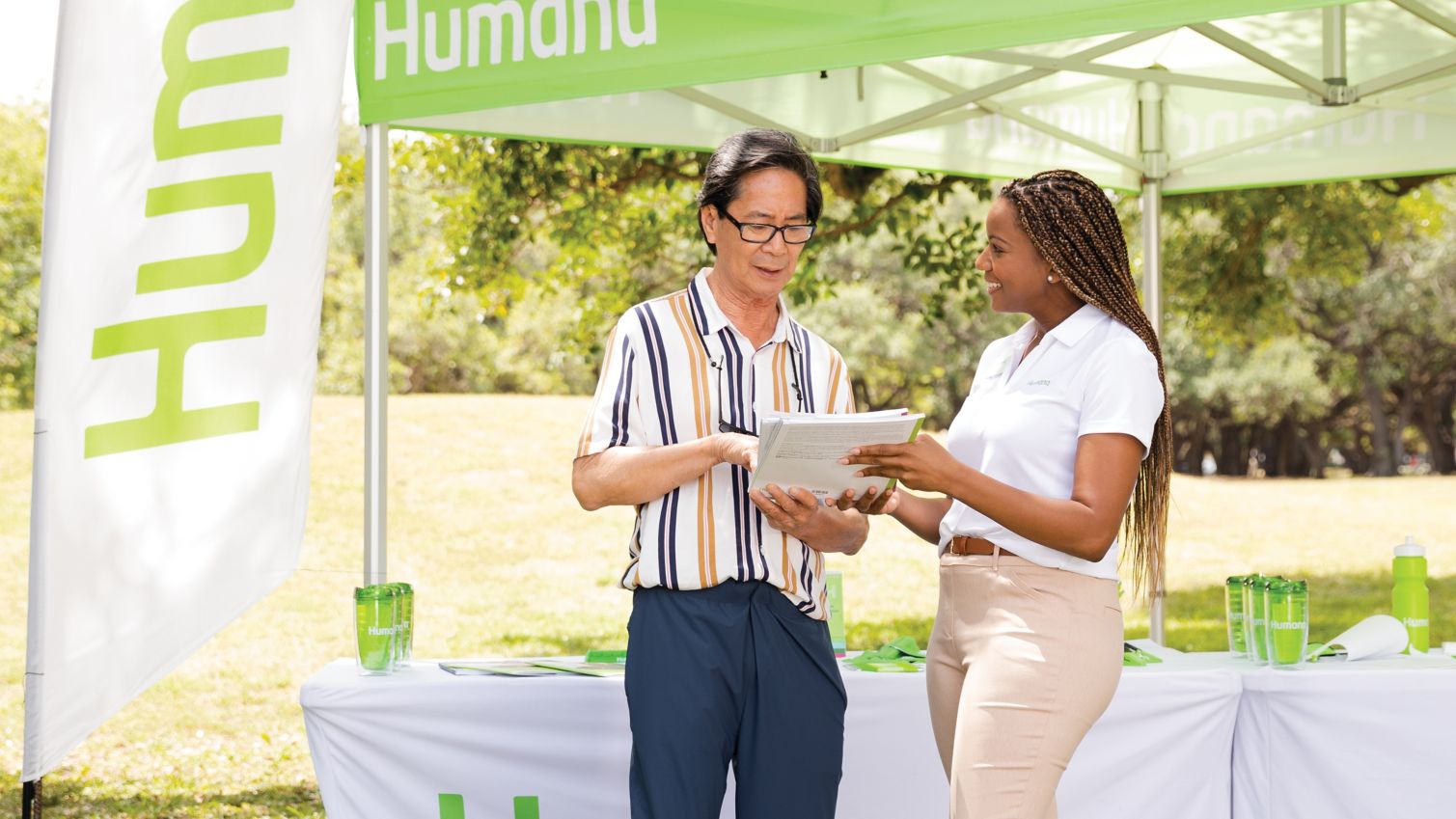 A man chats with a Humana agent at an outdoor event. 