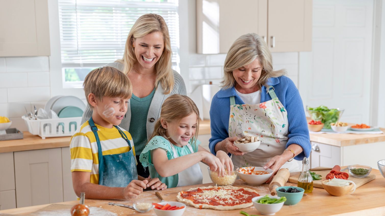 Family making a pizza in the kitchen.