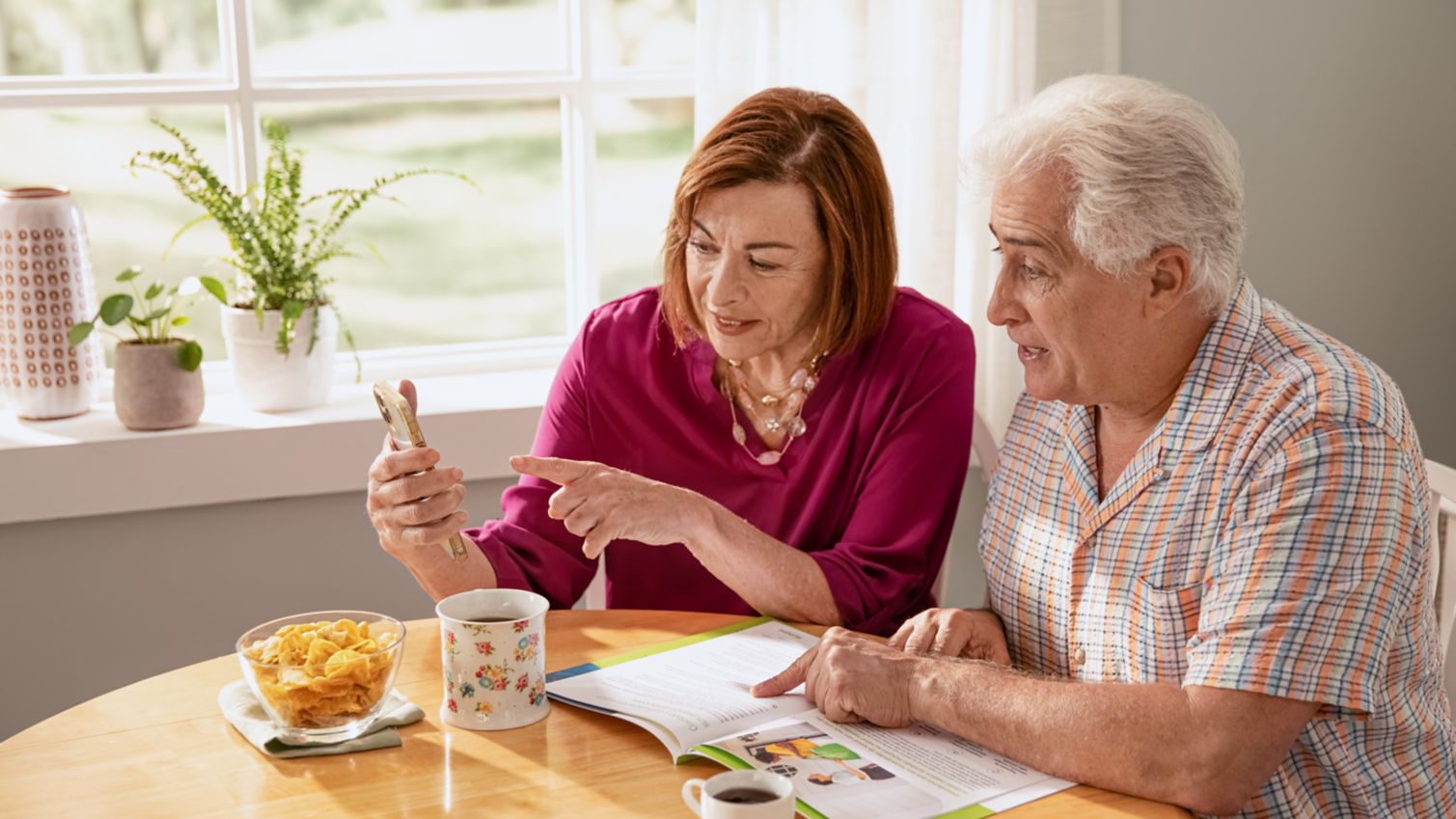 A couple looks over plan options over coffee in their kitchen.