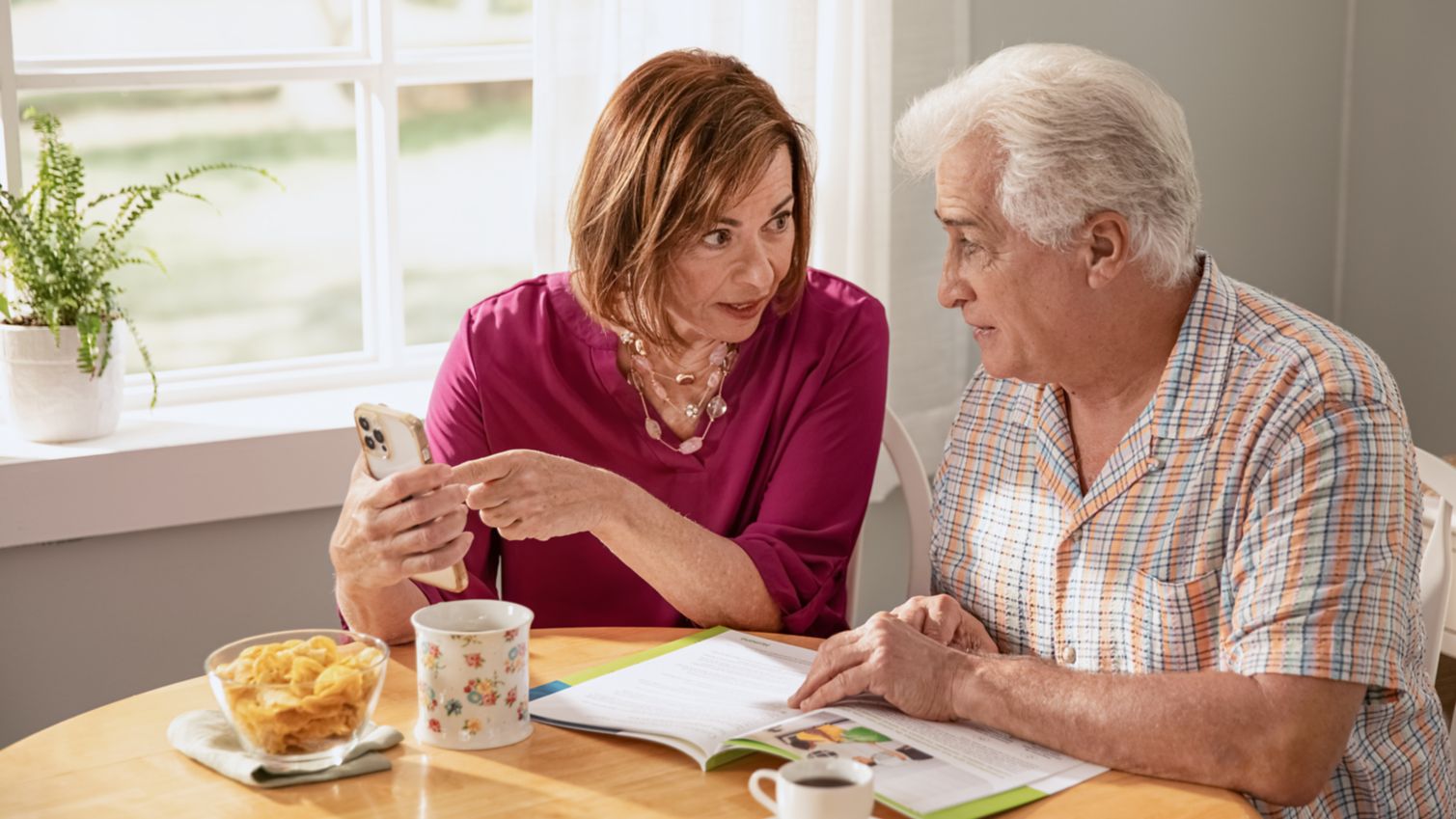 couple reviews Medicare info at the kitchen table
