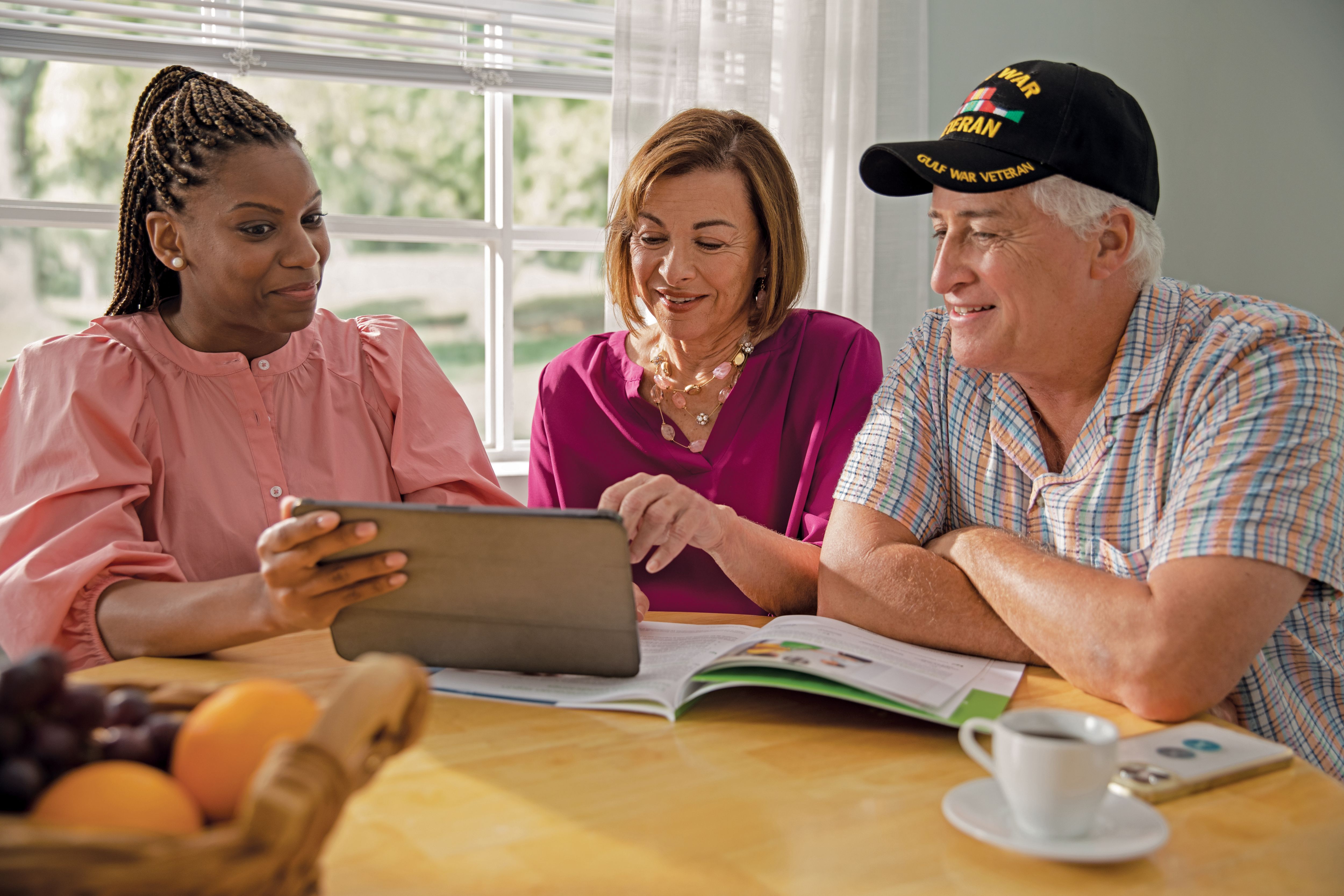 Senior couple sitting at table with sales agent reviewing materials