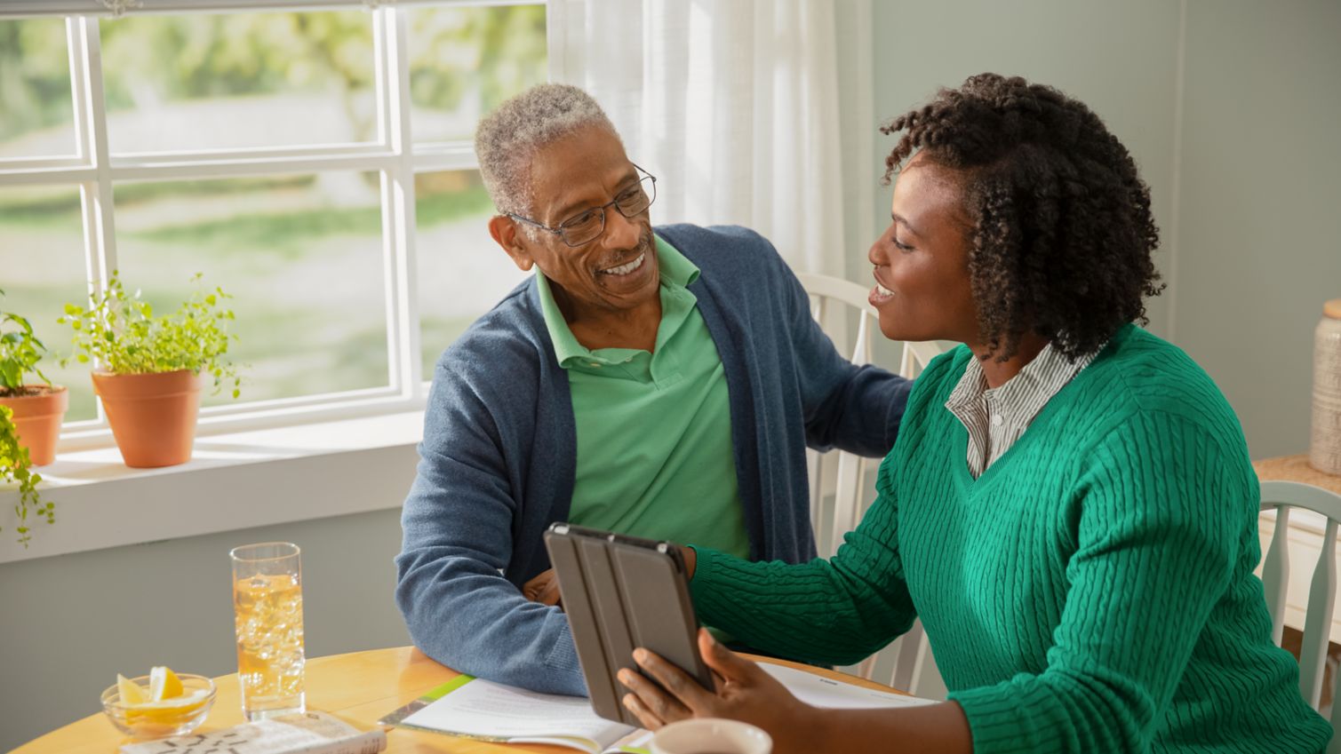 Senior man sits with adult daughter at table