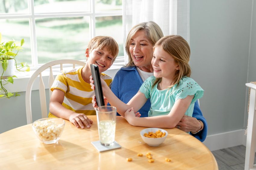 A woman makes a video call using a tablet with her gandkids.