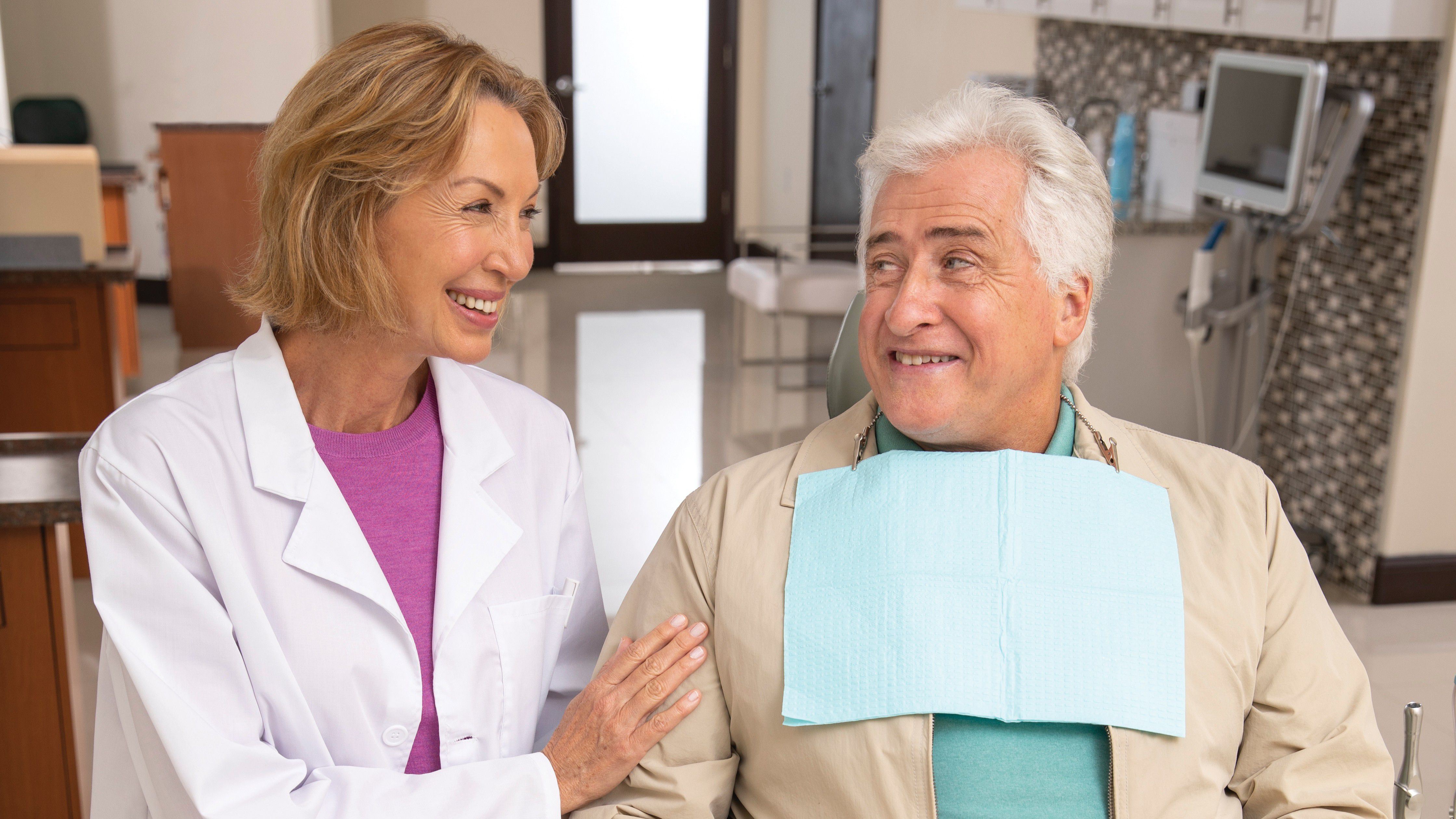 Man talks to dentist while in dental exam chair