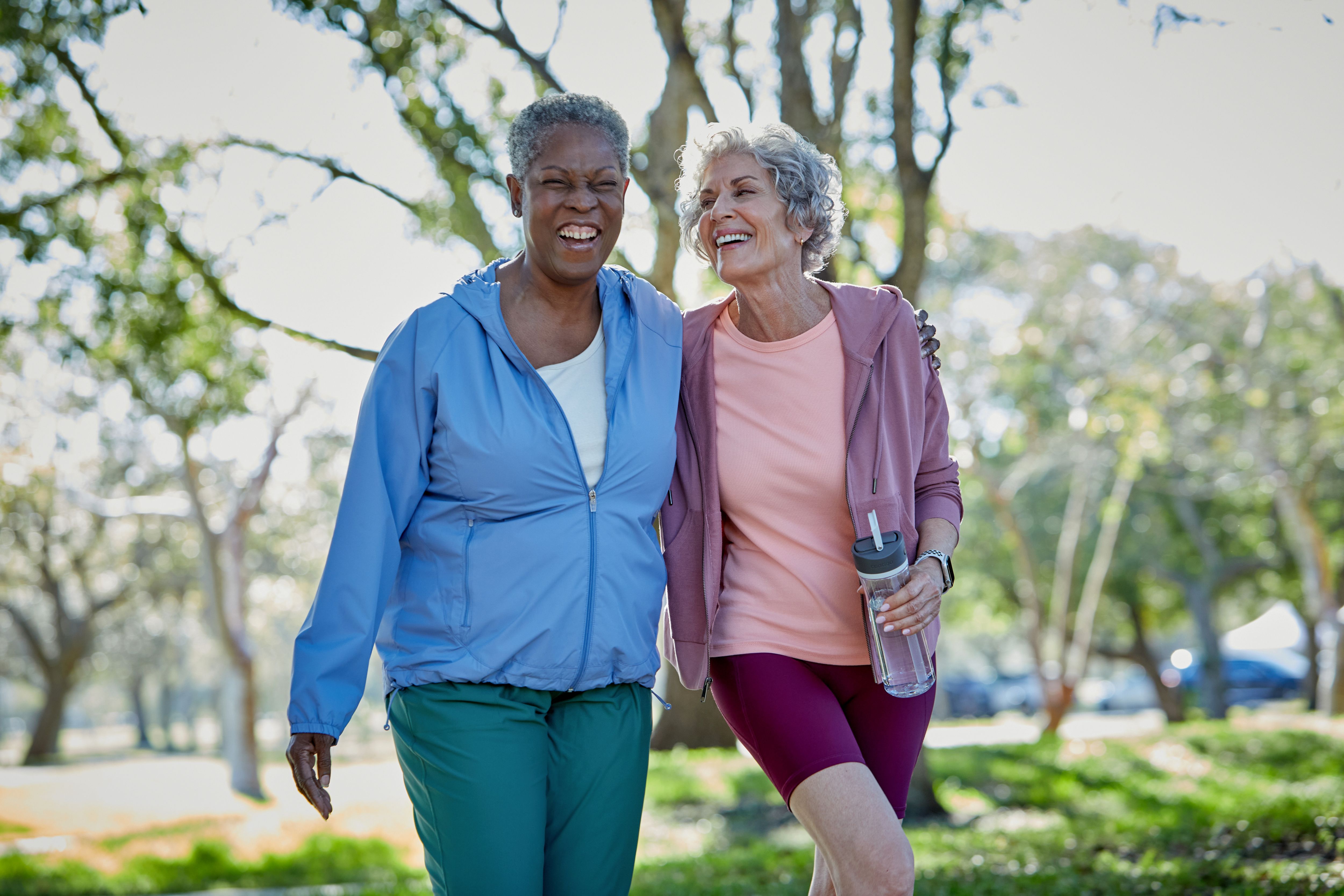 Two female seniors walking together at the park