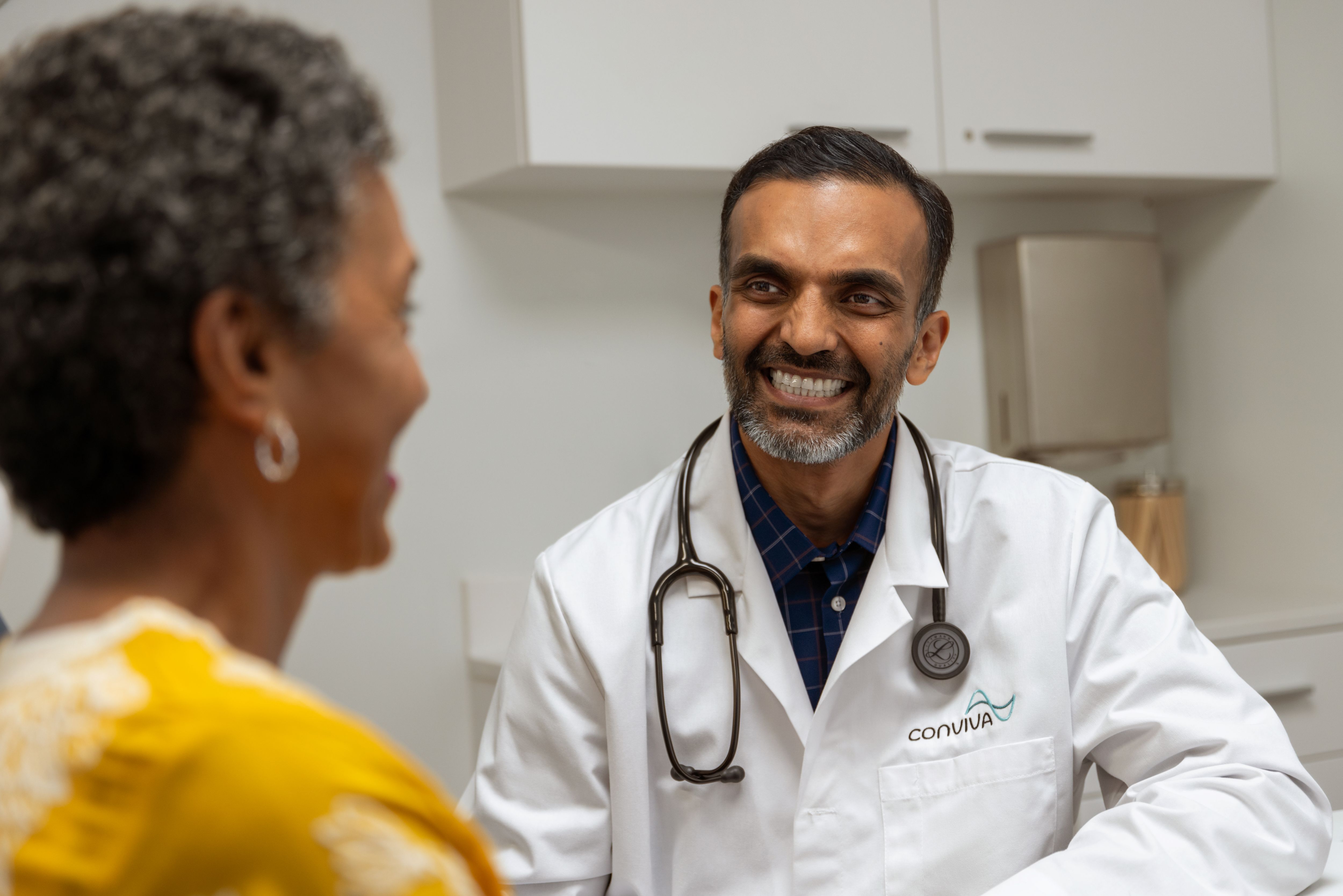 Indian male doctor with black female patient