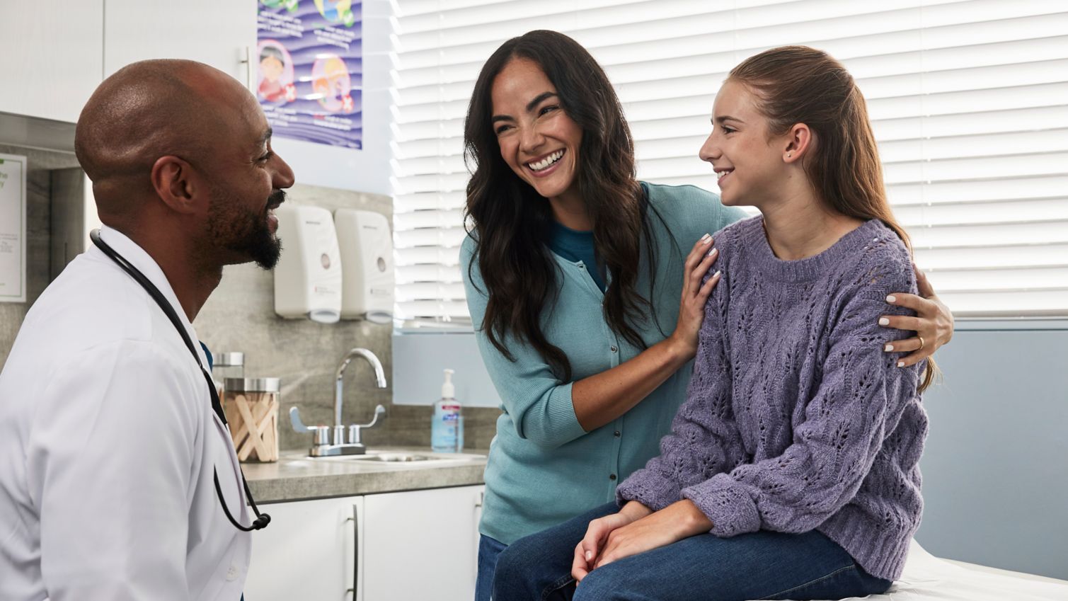 A child and parent in an exam room with a healthcare provider