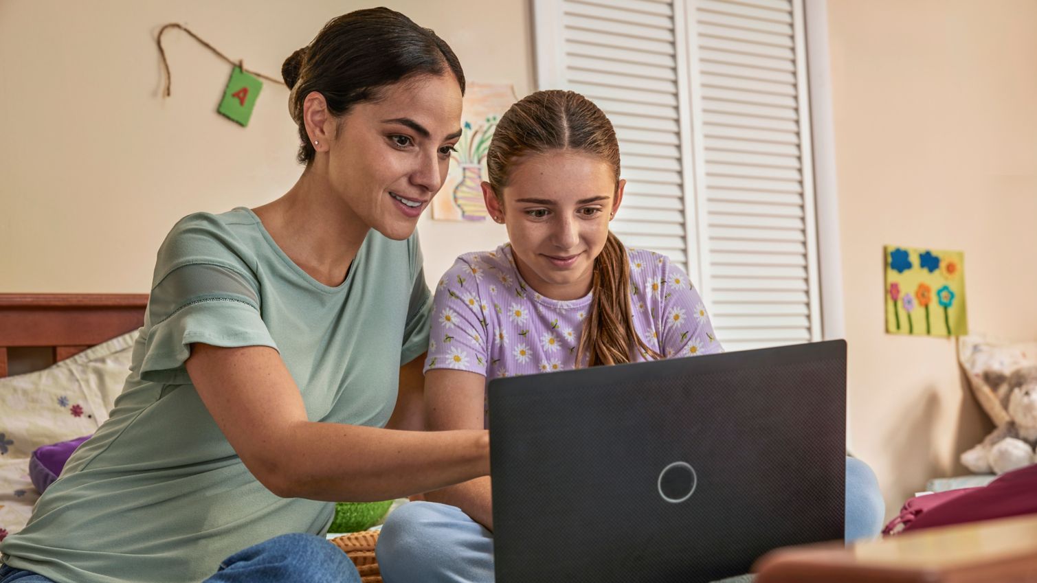 An adult and a child looking at a laptop computer