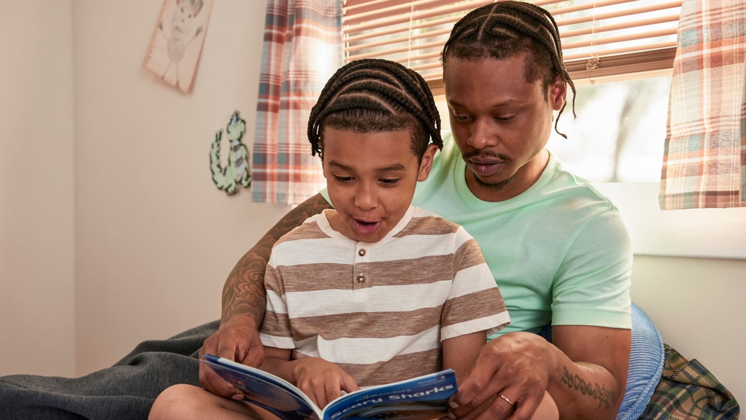 Parent reading child a book in bedroom