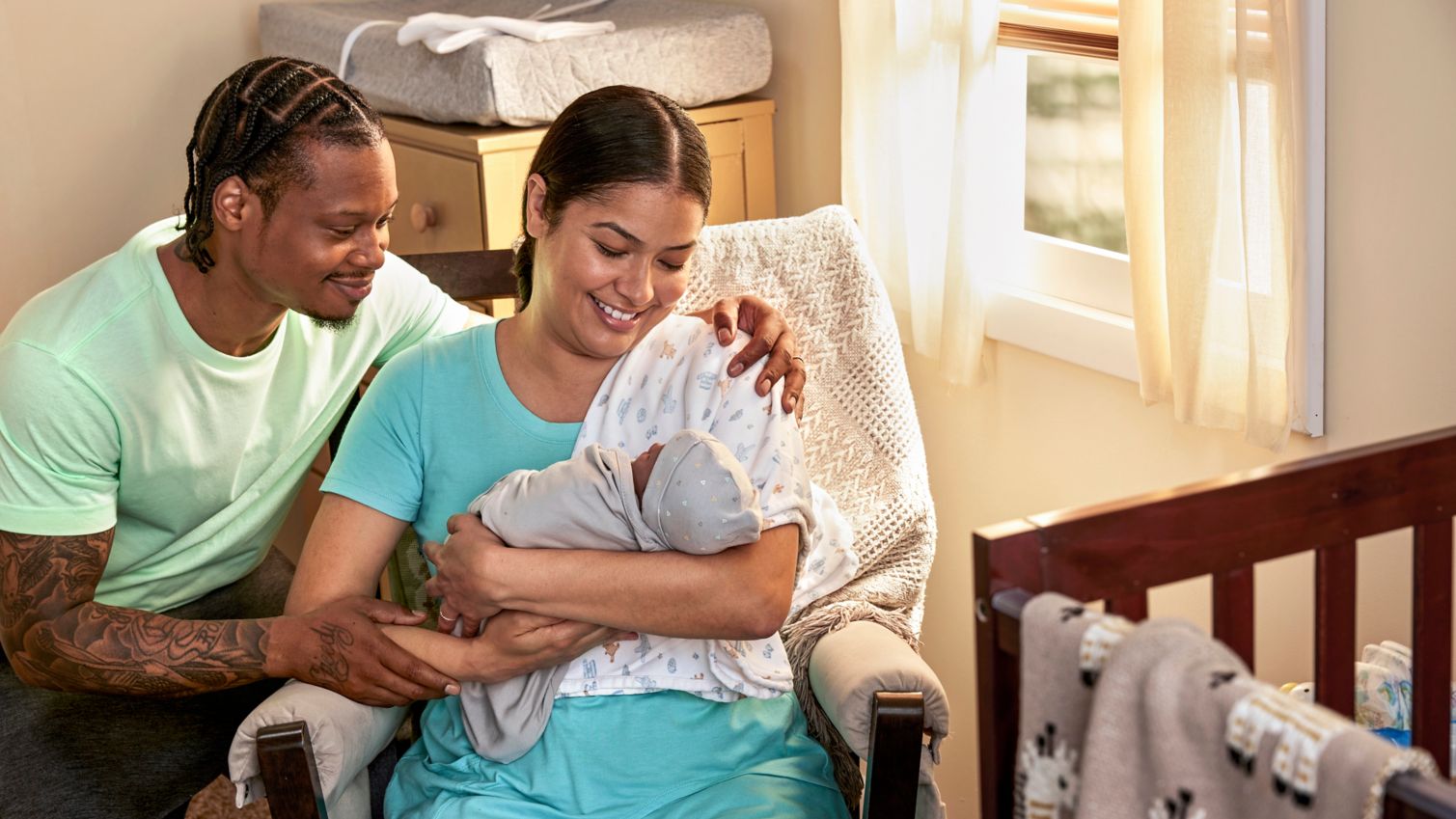 Two adults holding a newborn infant