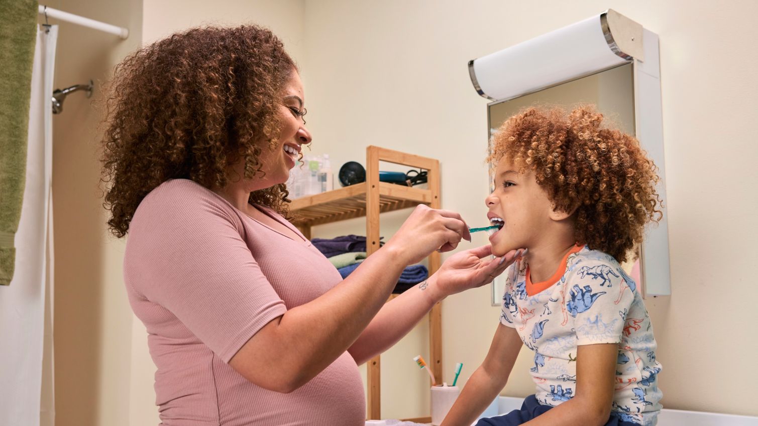 Pregnant mom brushing child's teeth