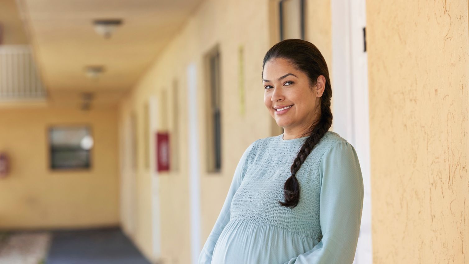Pregnant person outdoors, smiling