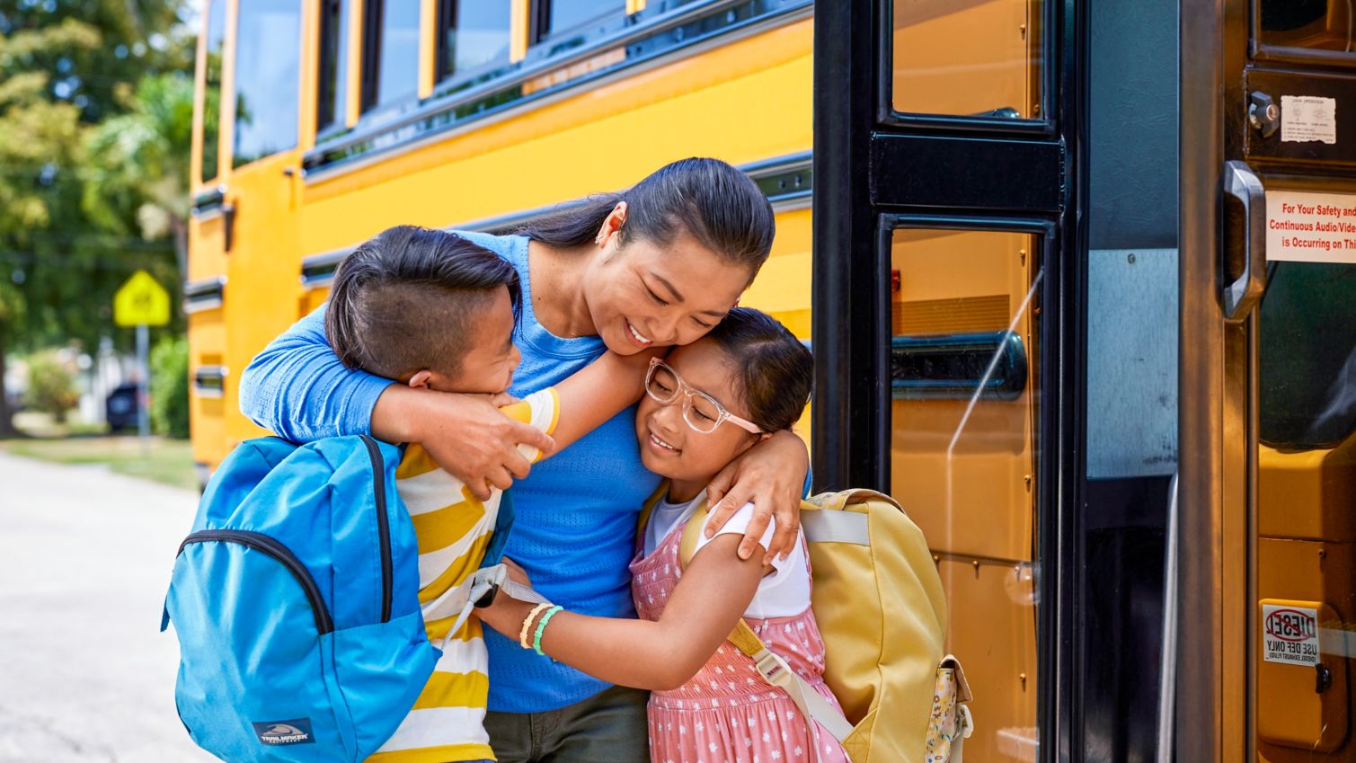 Parent hugging child getting off school bus