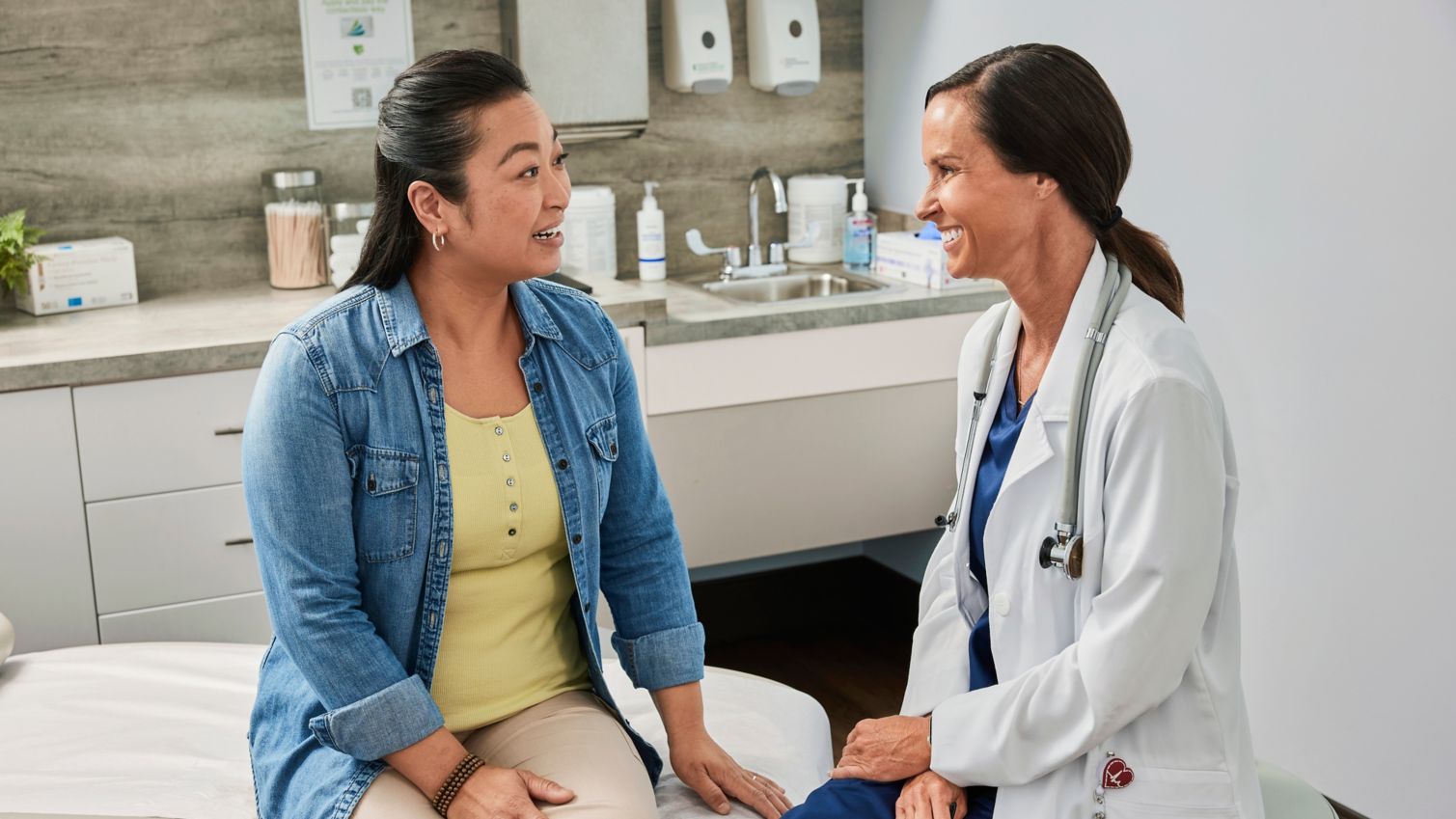 Adult meeting with a health provider in an exam room.