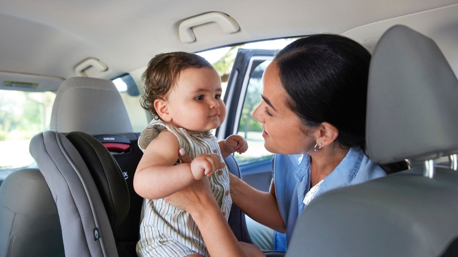 Mom lifting infant from car seat