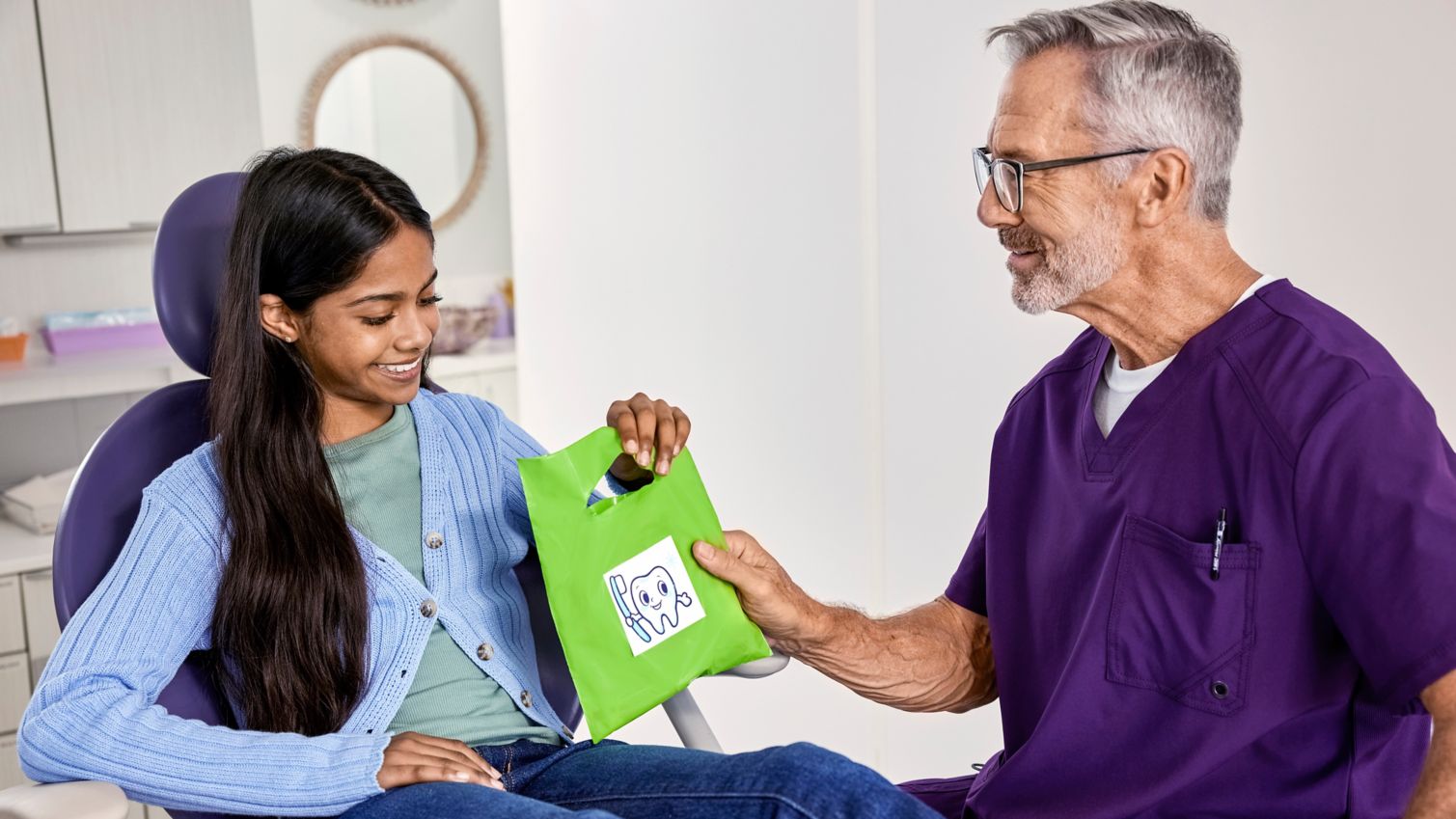 Teen receiving bag from dentist during exam