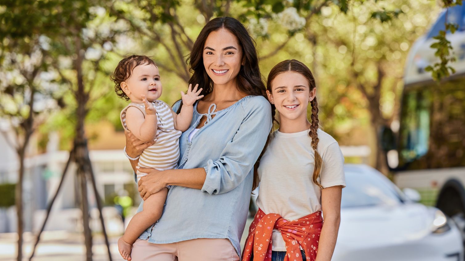 Mom, infant and teen smiling in portrait