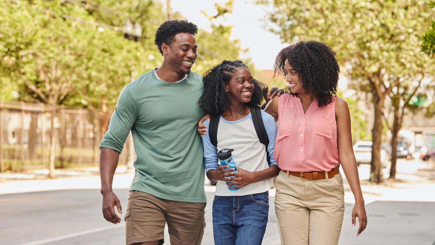 Two adults walking with a teen downtown