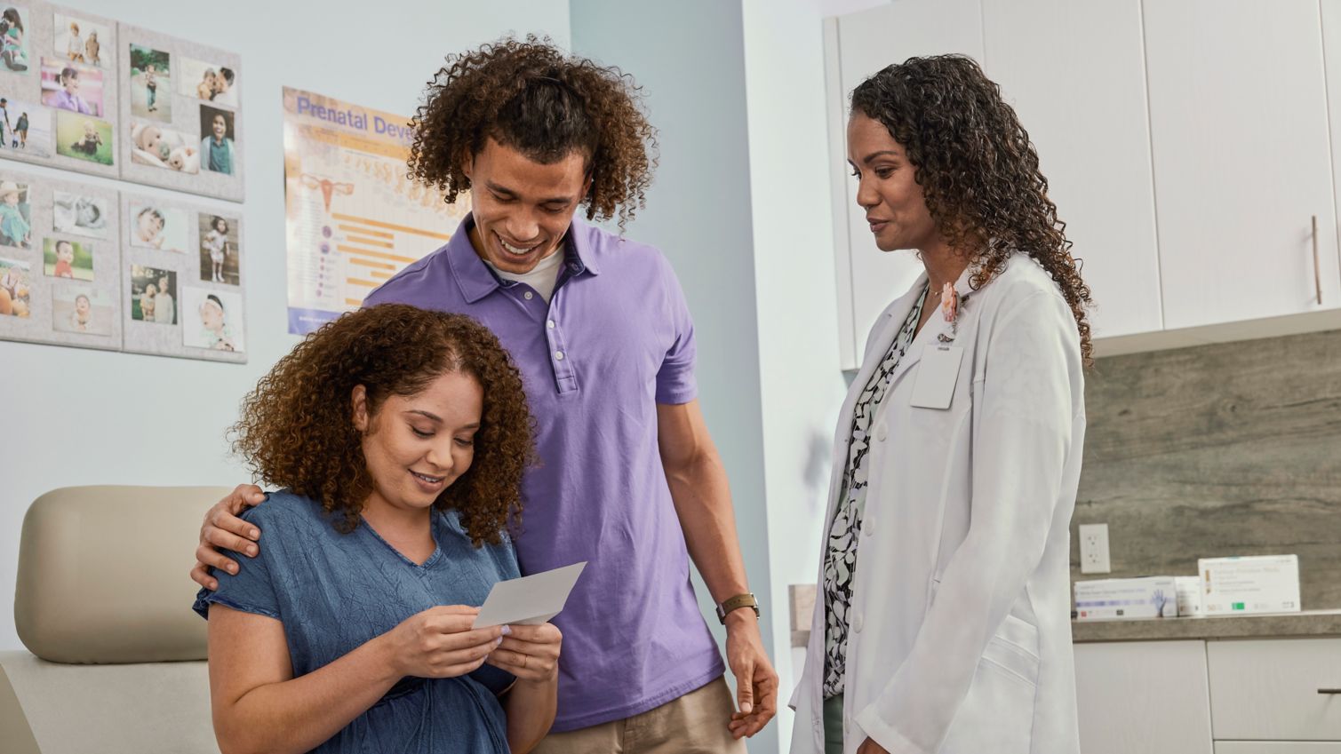 Adults viewing ultrasound photo with OBGYN