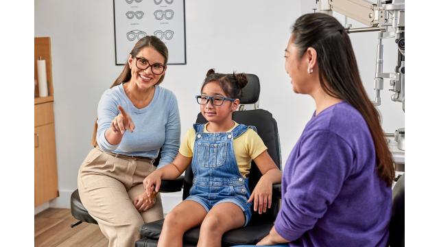 Child and parent talking with optometrist for exam