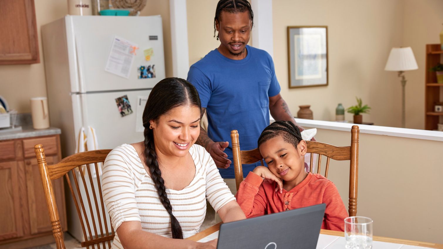 Parents and child viewing laptop