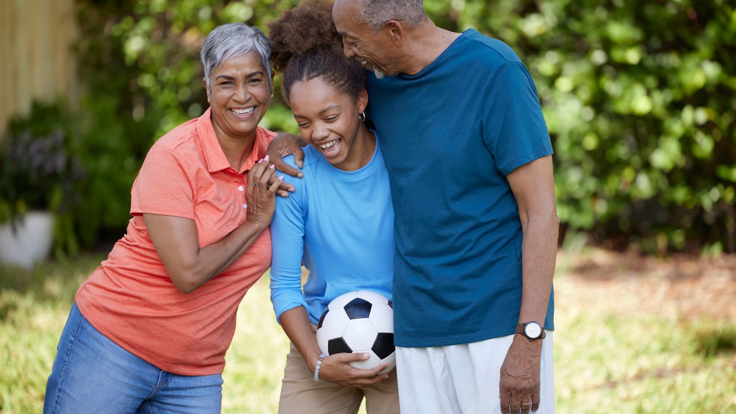 Seniors playing sports with child outdoors being active