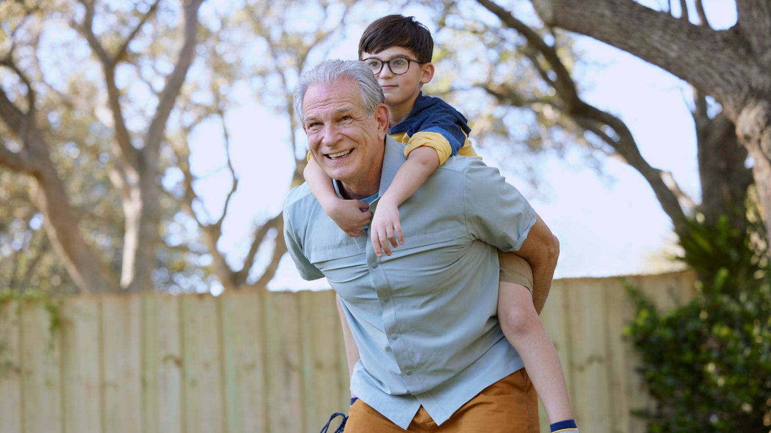 Senior playing sports with child outdoors being active