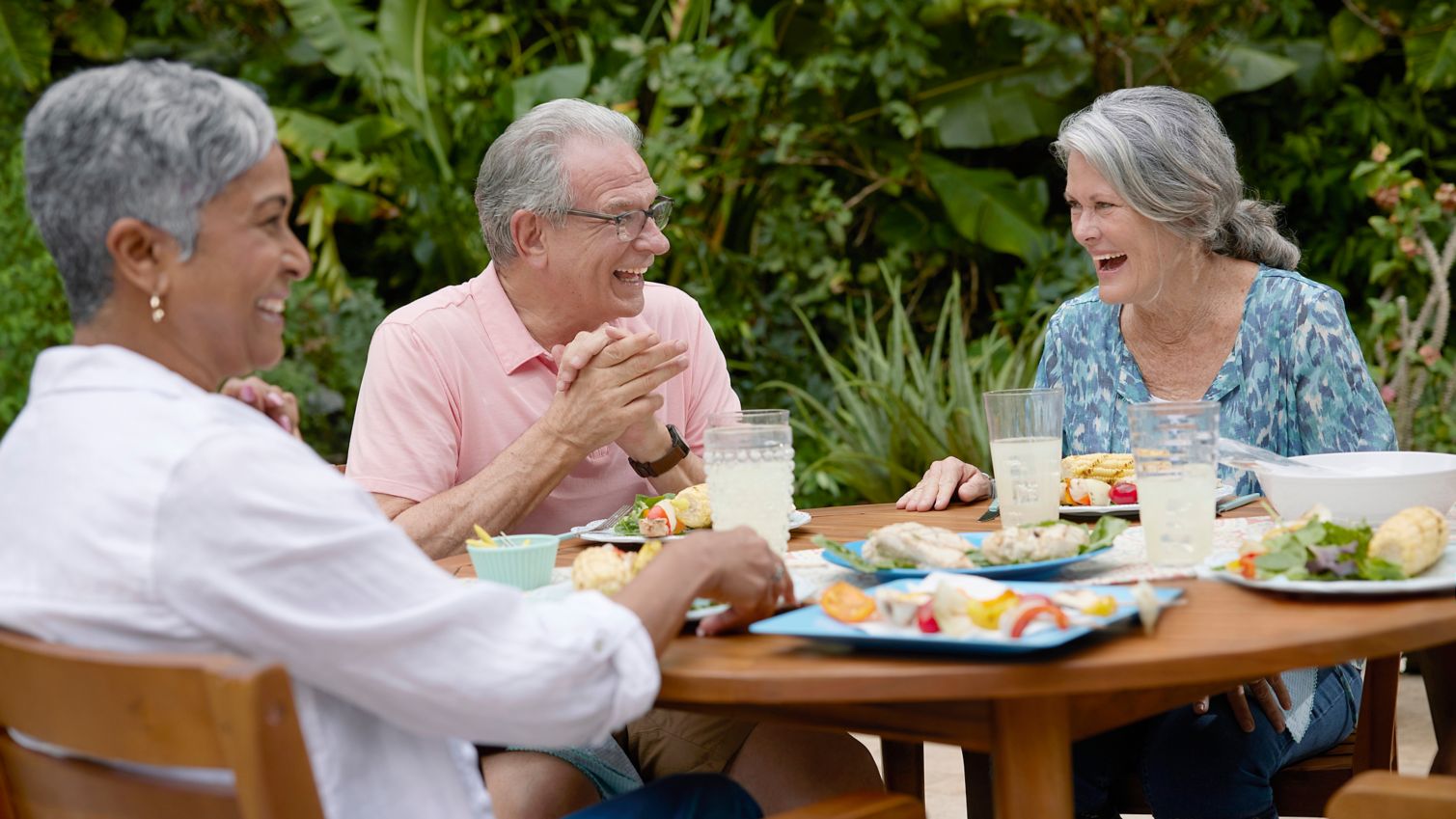 Seniors grilling and socializing outdoors on patio