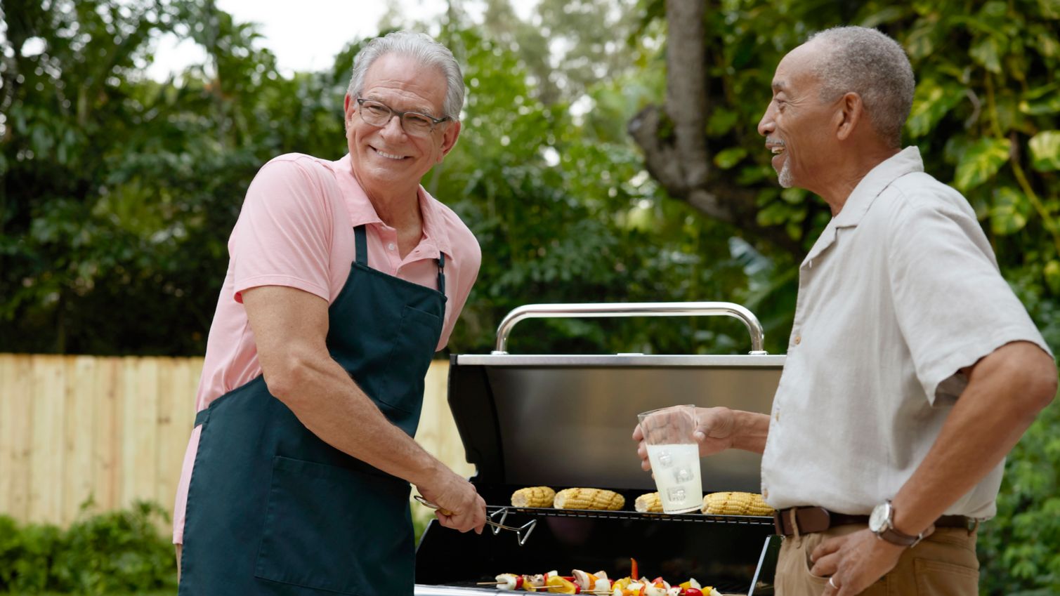 Seniors grilling and socializing outdoors on patio