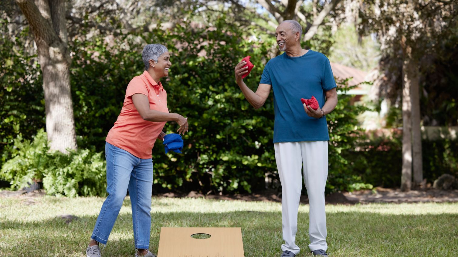 Two seniors playing cornhole