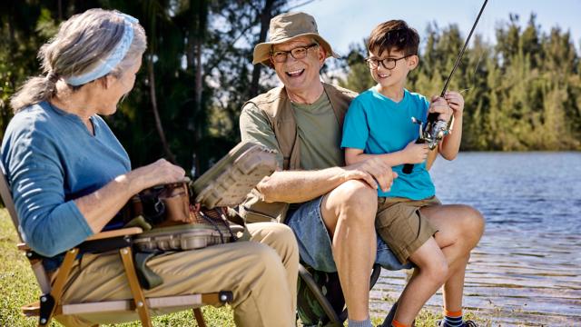 Seniors fishing near body of water with a child