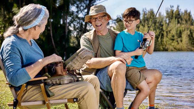 Seniors fishing near body of water with a child
