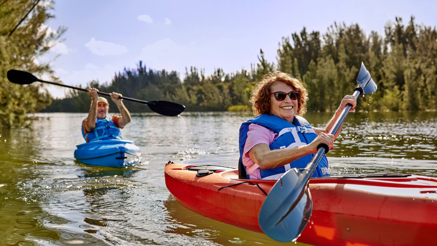 Two seniors kayaking on a river